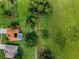 Aerial view of a property with a pool surrounded by lush green land and mature trees at 18168 Clearview Dr, Brooksville, FL 34604