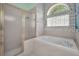 Bathroom with a garden tub, shower with glass door and white brick accents at 18168 Clearview Dr, Brooksville, FL 34604