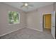 Spacious bedroom with tan walls, carpet flooring, ceiling fan, and natural light at 18168 Clearview Dr, Brooksville, FL 34604