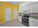 Bright kitchen featuring white cabinetry, tile floors, and stainless steel appliances at 18168 Clearview Dr, Brooksville, FL 34604