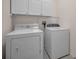 Well-equipped laundry room complete with a washer, dryer, and overhead cabinets at 18168 Clearview Dr, Brooksville, FL 34604