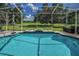 Screened-in pool and patio with ample seating and a view of the backyard at 18168 Clearview Dr, Brooksville, FL 34604