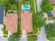 Aerial shot showcases the home's layout, featuring a private pool, lush landscaping, and spacious backyard at 18203 Tivoli Ln, Lutz, FL 33558