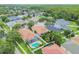 Aerial view of neighborhood showcasing the home with a screened-in pool and surrounding tree-lined streets at 18203 Tivoli Ln, Lutz, FL 33558