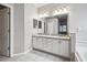 Bathroom featuring dual sinks with white cabinetry, tile flooring, and a framed mirror at 18203 Tivoli Ln, Lutz, FL 33558