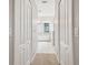 Hallway view leading to a bright bathroom with dual sinks and tile flooring at 18203 Tivoli Ln, Lutz, FL 33558