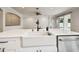 Bright kitchen island features a farmhouse sink, white cabinets, and stainless steel dishwasher at 18203 Tivoli Ln, Lutz, FL 33558