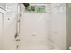 White tiled shower and tub combo with shower head and soap holder at 18203 Tivoli Ln, Lutz, FL 33558