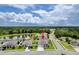 Aerial view of a gray home next to a pond and lush woods, showcasing its desirable location at 18527 Cortes Creek Blvd, Spring Hill, FL 34610