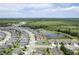 Aerial view of a home in a community with a pond and surrounded by lush greenery at 18527 Cortes Creek Blvd, Spring Hill, FL 34610