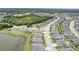 An aerial view shows the property's location in a neighborhood, near a lake and a green space with homes and landscaping at 18527 Cortes Creek Blvd, Spring Hill, FL 34610