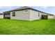 Exterior corner view of a well-maintained home with a spacious green lawn at 18527 Cortes Creek Blvd, Spring Hill, FL 34610
