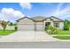Charming single-story home with a three-car garage and well-maintained landscaping, under a blue sky at 18527 Cortes Creek Blvd, Spring Hill, FL 34610