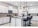 Bright kitchen with white cabinetry, granite countertops, stainless steel appliances, and island seating at 18527 Cortes Creek Blvd, Spring Hill, FL 34610