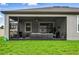 Home showcasing a screened-in lanai with comfortable seating and an outdoor fan at 18527 Cortes Creek Blvd, Spring Hill, FL 34610