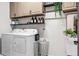 Functional laundry room with washer, dryer, storage cabinets, and a utility sink at 18527 Cortes Creek Blvd, Spring Hill, FL 34610