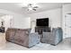 Bright living room featuring tile floors, comfortable gray sofas, and a mounted television at 18527 Cortes Creek Blvd, Spring Hill, FL 34610