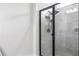 Modern bathroom shower featuring gray tile, a glass enclosure, and a rainfall shower head at 18527 Cortes Creek Blvd, Spring Hill, FL 34610