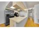 The kitchen area features hardwood floors, stainless steel appliances, and a breakfast bar at 1902 Elaine Dr, Clearwater, FL 33760