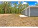 Side view of the house highlighting the backyard, patio area, and siding at 19275 Wildwood Dr, Brooksville, FL 34601