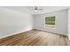 Bright bedroom with wood-look flooring, a window for natural light and neutral paint at 19275 Wildwood Dr, Brooksville, FL 34601