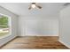 Bedroom featuring wood-look floors, ceiling fan, window, and closet with folding doors at 19275 Wildwood Dr, Brooksville, FL 34601