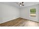 Bedroom featuring wood-look flooring, a ceiling fan and natural light shining through the window at 19275 Wildwood Dr, Brooksville, FL 34601