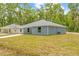 View of new construction with gray vinyl siding, a sidewalk, and a spacious yard at 19275 Wildwood Dr, Brooksville, FL 34601