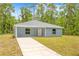Charming single-story home with light blue siding, well-manicured lawn, and inviting front entrance at 19275 Wildwood Dr, Brooksville, FL 34601