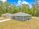 Exterior view of two matching homes with blue and yellow siding, white trim, and matching driveways at 19275 Wildwood Dr, Brooksville, FL 34601