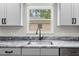 Close-up on modern kitchen sink featuring elegant fixtures and granite countertops at 19275 Wildwood Dr, Brooksville, FL 34601