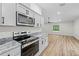Bright kitchen with white cabinets, stainless steel appliances, and modern countertops at 19275 Wildwood Dr, Brooksville, FL 34601