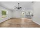 Open living area with wood floors, large windows, and a view to the updated kitchen at 19275 Wildwood Dr, Brooksville, FL 34601