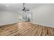 Bright living room with modern wood floors, ceiling fan, and views of the kitchen at 19275 Wildwood Dr, Brooksville, FL 34601