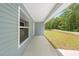The home features a covered porch with a large picture window, offering a tranquil view of the outdoor greenery at 19275 Wildwood Dr, Brooksville, FL 34601