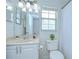 All-white bathroom with marble countertops and a large mirror above the vanity and a bathtub with shower behind a curtain at 19555 Timberbluff Dr, Land O Lakes, FL 34638
