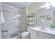 Well-lit bathroom with marble countertops, white vanity and tile walls, and a walk-in shower with glass doors at 19555 Timberbluff Dr, Land O Lakes, FL 34638