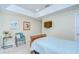 Bedroom with light walls, tile flooring, small accent table, framed art, and a mounted TV at 19555 Timberbluff Dr, Land O Lakes, FL 34638