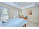 Bright bedroom with tray ceiling, tan walls, tile floor, large window and sliding doors with elegant curtains at 19555 Timberbluff Dr, Land O Lakes, FL 34638