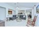 Open-concept living area featuring a modern sofa, glass table, and view into the adjoining kitchen and dining area at 19555 Timberbluff Dr, Land O Lakes, FL 34638