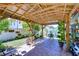 Covered patio area featuring brick pavers, surrounded by lush greenery and a garden at 19555 Timberbluff Dr, Land O Lakes, FL 34638