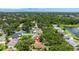 Expansive aerial view of the property in a lush, green neighborhood with mature trees and a glimpse of the water in the distance at 2068 Diane Ave, Palm Harbor, FL 34683