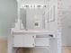 Bathroom vanity featuring extensive lighting, a large mirror, and under-sink storage at 2068 Diane Ave, Palm Harbor, FL 34683
