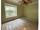 Bedroom with a large window offering views of greenery and a ceiling fan providing air circulation at 2068 Diane Ave, Palm Harbor, FL 34683