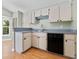 Efficient kitchen featuring wood floors, white cabinets, and black appliances at 2068 Diane Ave, Palm Harbor, FL 34683