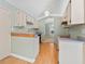 Galley style kitchen featuring classic white cabinets, neutral walls, and wood laminate flooring at 2068 Diane Ave, Palm Harbor, FL 34683