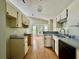Bright kitchen with cream cabinets, laminate countertops, wood flooring, a breakfast nook, and bay windows at 2068 Diane Ave, Palm Harbor, FL 34683