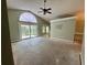 Spacious living room with high vaulted ceilings, a ceiling fan, and sliding glass doors to the backyard at 2068 Diane Ave, Palm Harbor, FL 34683
