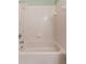 Bathroom featuring a bathtub with a shower head and tiled walls at 2068 Diane Ave, Palm Harbor, FL 34683