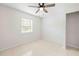 Bright bedroom with tile flooring, neutral walls, and a ceiling fan at 2141 Coachman Rd, Spring Hill, FL 34608